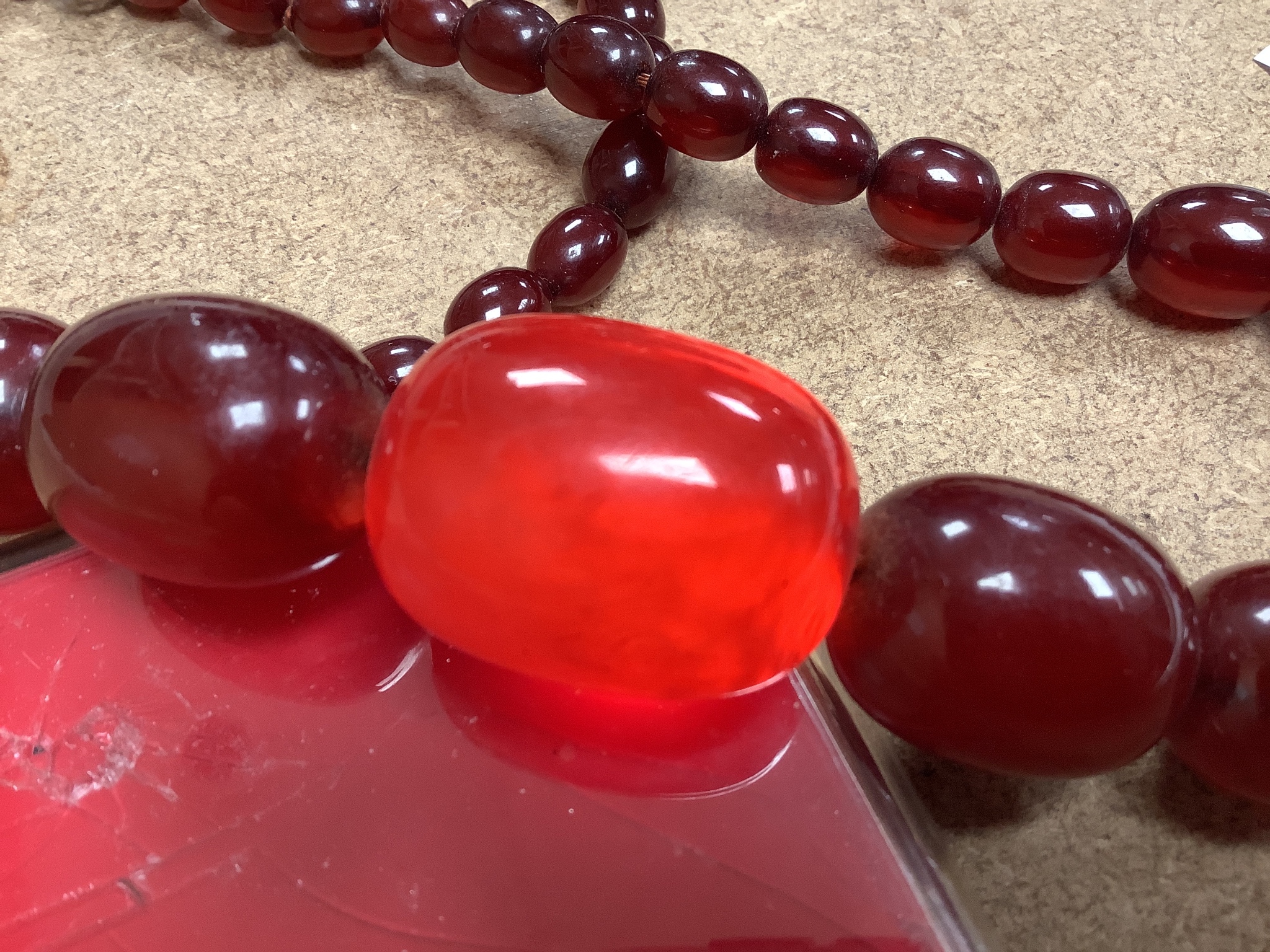 A double strand simulated oval cherry amber bead choker necklace (string broken), 44cm, gross weight 102 grams.